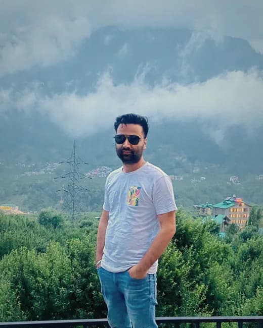Randhir, co-founder of HimVeda, standing in front of a cloud-covered mountain valley